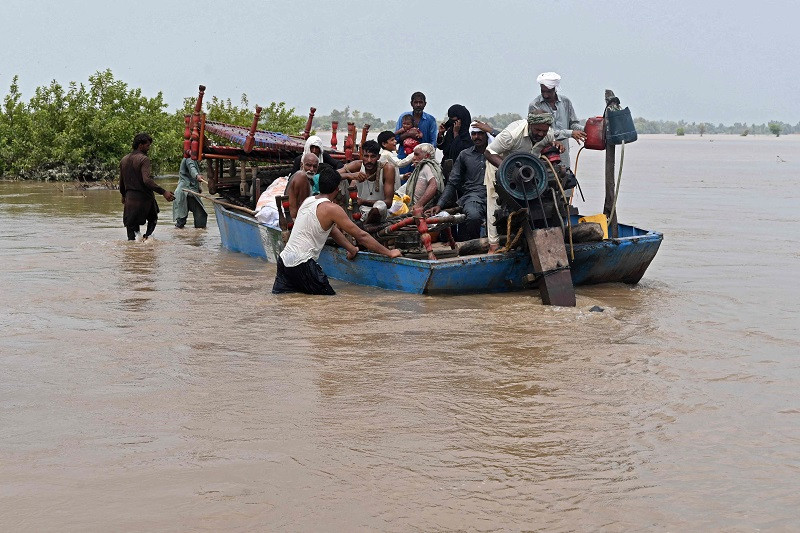 people with their belongings wade through the flood affected area of chanda singh wala village in kasur district on august 22 2023 photo afp