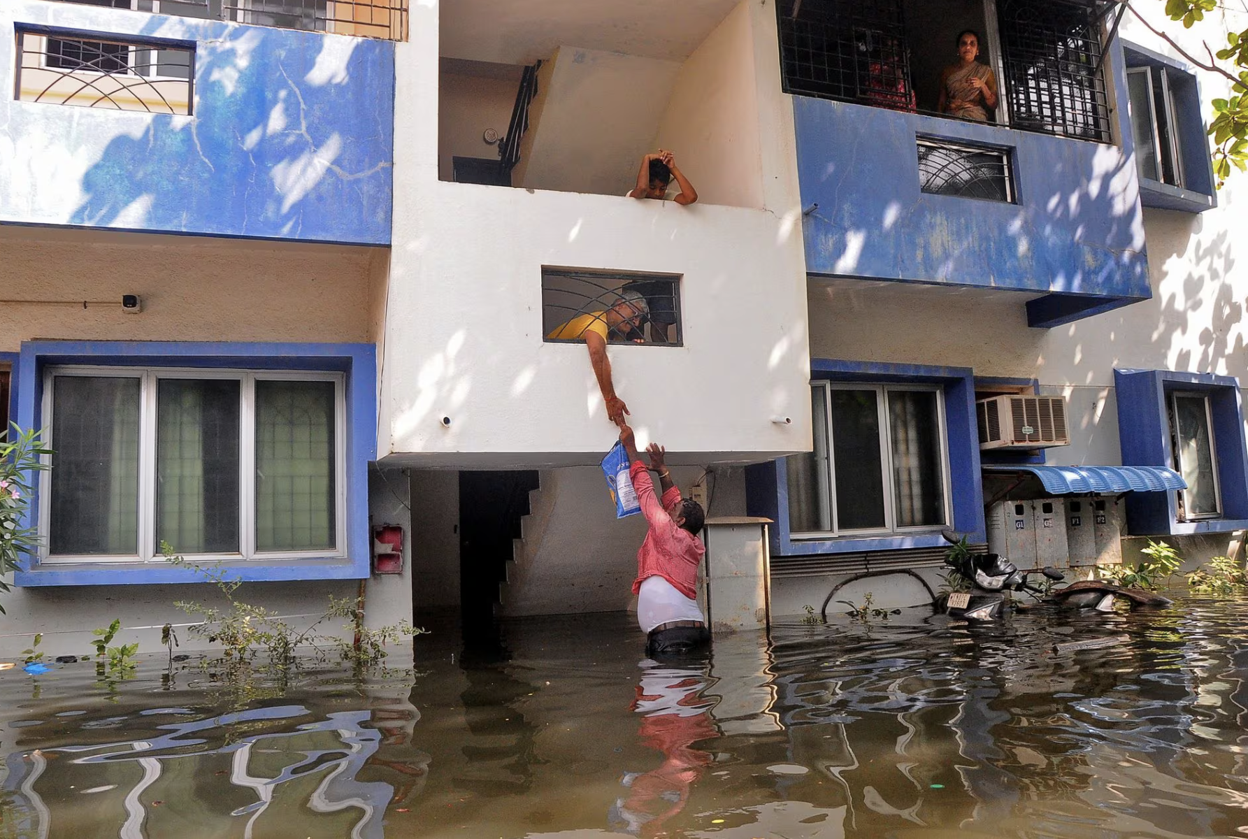 photo a volunteer offers food to a resident after his house got partially submerged following heavy rains due to cyclone michaung in chennai india december 6 2023 reuters