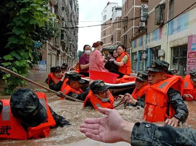 paramilitary police officers evacuate residents stranded by floodwaters with a boat following heavy rainfall in hedian town of suizhou hubei province china august 12 2021 photo reuters paramilitary police officers evacuate residents stranded by floodwaters with a boat following heavy rainfall in hedian town of suizhou hubei province china august 12 2021 photo reuters