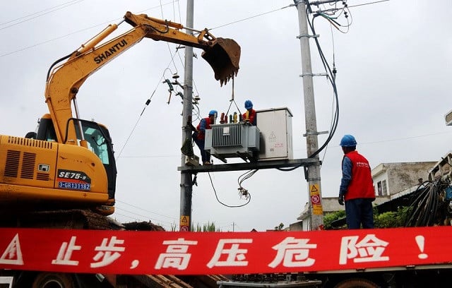 Workers replace a damaged transformer following heavy rainfall in Neixiang county of Nanyang, Henan province, China July 21, 2021. PHOTO: REUTERS