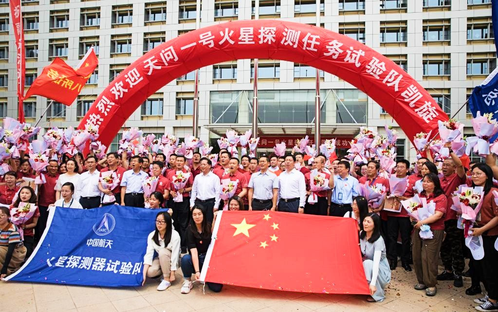 Staff members of China's Tianwen-1 Mars exploration mission and welcoming crowd pose for photos in Beijing, capital of China, June 11, 2021. PHOTO: XINHUA