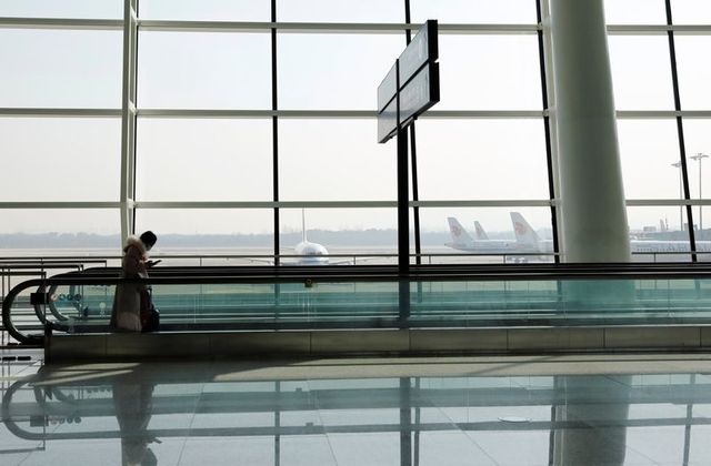 a traveller checks her mobile phone at wuhan tianhe international airport following the coronavirus disease covid 19 outbreak in wuhan hubei province china january 2 2021 photo reuters