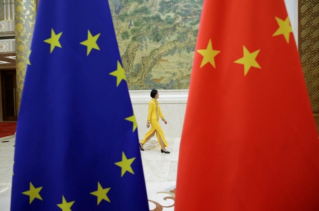 an attendant walks past eu and china flags ahead of the eu china high level economic dialogue at diaoyutai state guesthouse in beijing china june 25 2018 photo reuters