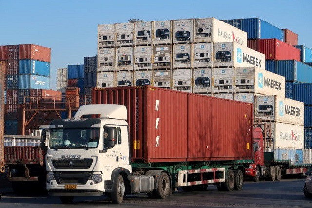 a worker drives a truck carrying a container at a logistics center near tianjin port in tianjin china december 12 2019 photo reuters