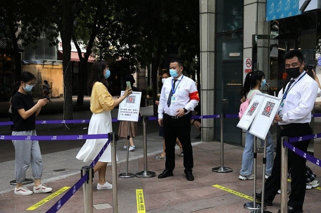 a woman shows her health status on a phone to a security guard at an entrance of a shopping mall in beijing china august 23 2021 photo reuters a woman shows her health status on a phone to a security guard at an entrance of a shopping mall in beijing china august 23 2021 photo reuters