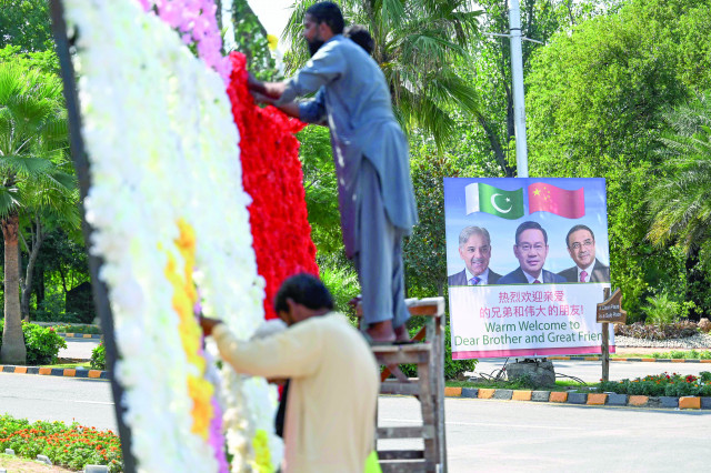 workers decorate a street near a billboard featuring images of china s premier li qiang prime minister shehbaz sharif and president asif ali zardari in islamabad photo afp workers decorate a street near a billboard featuring images of china s premier li qiang prime minister shehbaz sharif and president asif ali zardari in islamabad photo afp