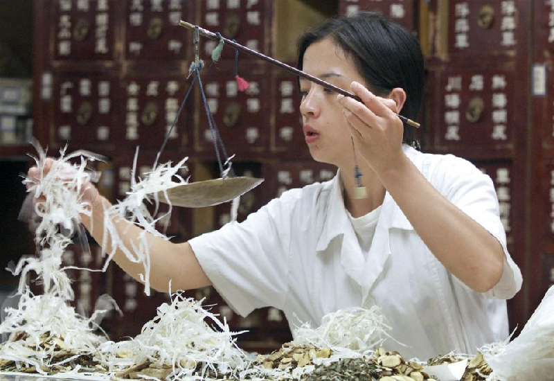 a chinese pharmacist fills a prescription of chinese herbal medicine at a herbal medicine store in beijing august 7 2000 photo reuters