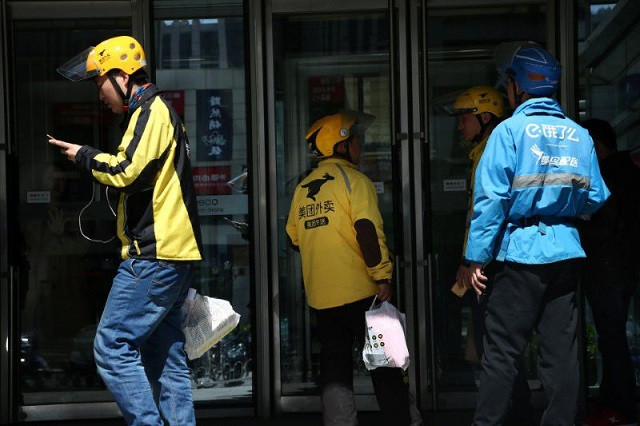 drivers of food delivery service ele me in blue and meituan in yellow are seen in beijing china april 11 2018 photo reuters
