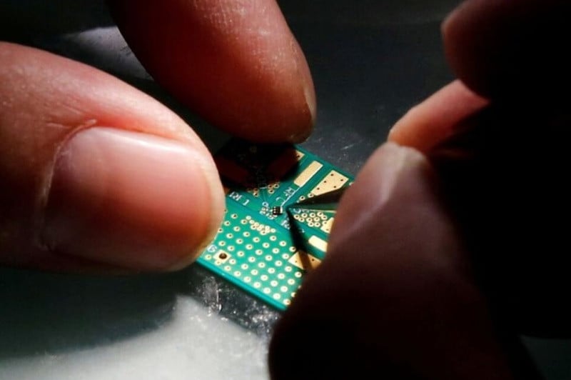 a researcher plants a semiconductor on an interface board during a research work to design and develop a semiconductor product at tsinghua unigroup research centre in beijing china february 29 2016 photo reuters