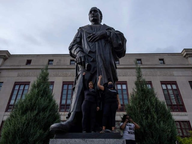 protesters raise their fists as they stand on the base of a statue of christopher columbus in front of city hall during an international march for black lives protest against police brutality in downtown columbus ohio photo afp file protesters raise their fists as they stand on the base of a statue of christopher columbus in front of city hall during an international march for black lives protest against police brutality in downtown columbus ohio photo afp file