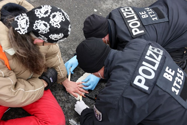 police officers unglue a letzte generation last generation activist s hand during a protest against food waste and for an agricultural change to reduce greenhouse gas emissions in berlin germany february 7 2022 photo reuters