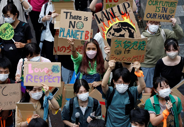 people raise placards as they take part in a global climate protest march at omotesando district in tokyo japan september 23 2022 photo reuters people raise placards as they take part in a global climate protest march at omotesando district in tokyo japan september 23 2022 photo reuters
