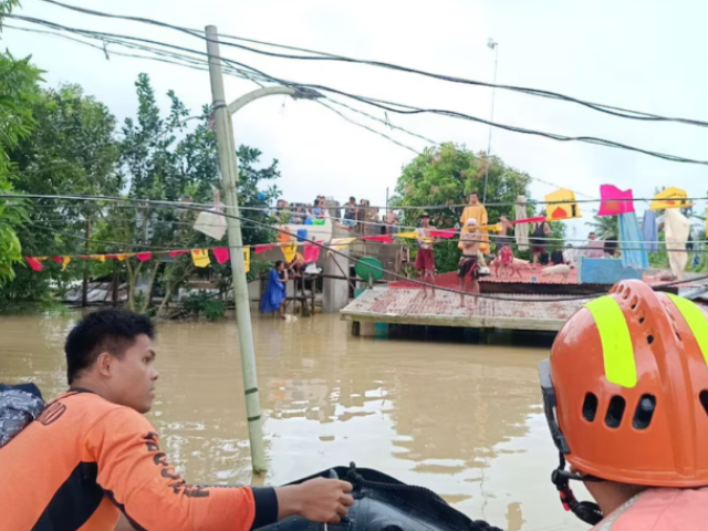 Philippine Coast Guard personnel rescue residents after flood waters rose from heavy rains brought by Tropical Storm Trami, in Bicol, Philippines, October 23, 2024. PHILIPPINE COAST GUARD/Handout via REUTERS