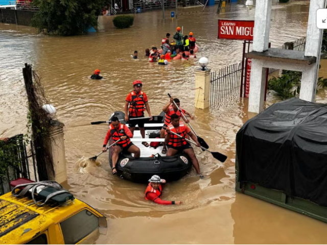 philippine coast guard personnel evacuate residents after flood waters rose due to heavy rains brought by tropical storm trami in camarines sur philippines via philippine coast guard