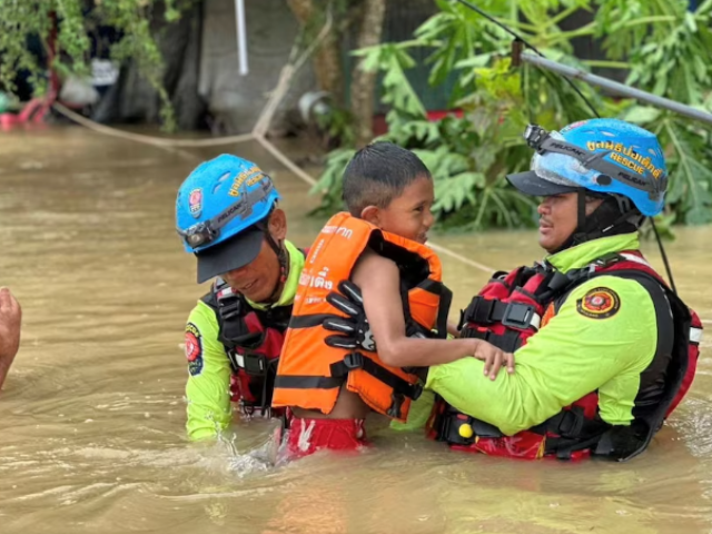 rescue workers evacuate a child stranded by flooding in sateng nok yala province thailand november 30 2024 in this picture obtained from social media poh teck tung foundation via reuters