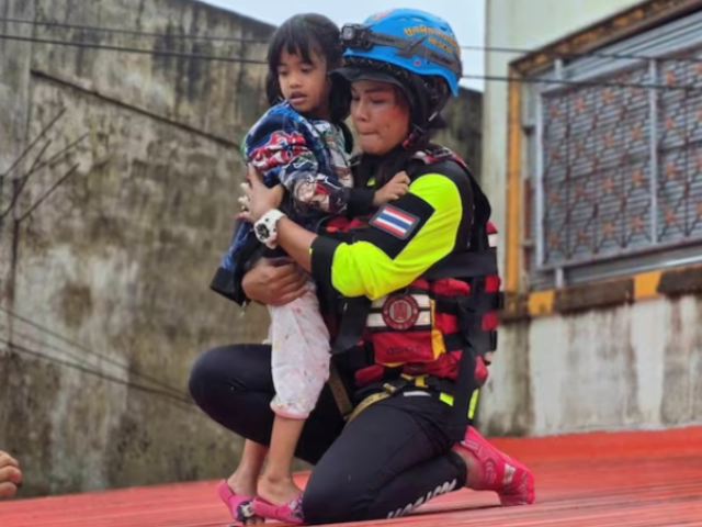 A rescue worker evacuates a child stranded by flooding in Sateng Nok, Yala Province, Thailand, November 30, 2024, in this picture obtained from social media. Poh Teck Tung Foundation/via REUTERS