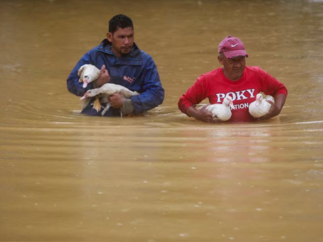 Men wade through floodwaters after performing prayers at a mosque in Hulu Terengganu, Malaysia, November 29, 2024. REUTERS/ Stringer