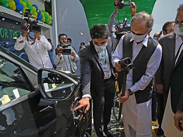pakistan s federal minister for energy omar ayub khan prepares to charge an electric car photo afp