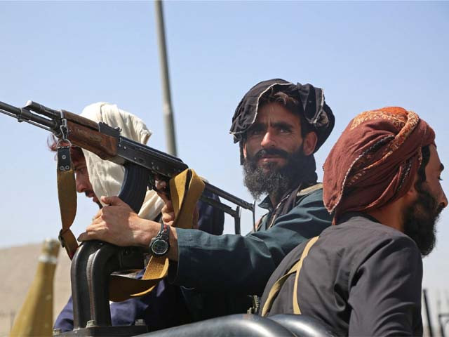 taliban fighters stand guard in a vehicle along the roadside photo afp file