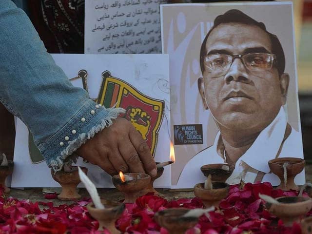 a member of the human rights council of pakistan places an oil lamp to pay tribute to sri lankan factory manager priyantha kumara photo afp file