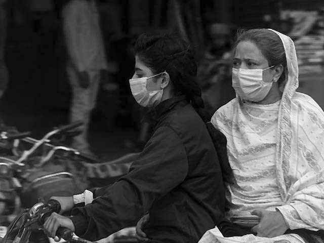 women wearing facemasks ride on a motorbike in karachi photo afp