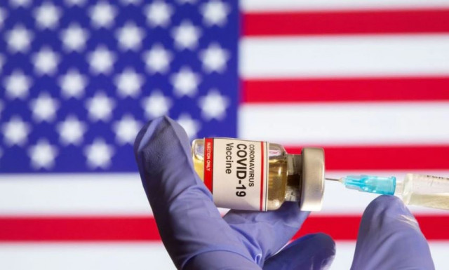 a woman holds a small bottle labeled with a coronavirus covid 19 vaccine sticker and a medical syringe in front of displayed usa flag in this illustration taken october 30 2020 photo reuters file a woman holds a small bottle labeled with a coronavirus covid 19 vaccine sticker and a medical syringe in front of displayed usa flag in this illustration taken october 30 2020 photo reuters file