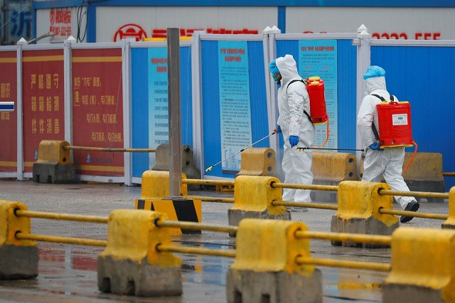 workers in ppe spray the ground with diinfectant in baishazhou market during a visit of world health organization who team tasked with investigating the origins of the coronavirus covid 19 pandemic in wuhan hubei province china january 31 2021 photo reuters