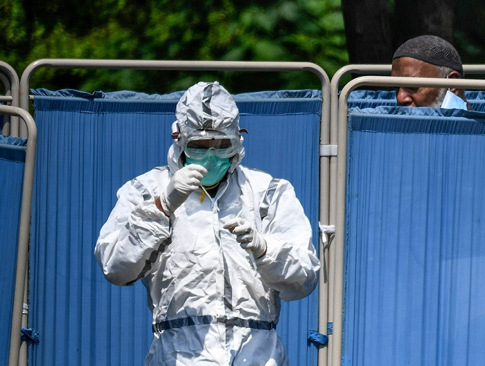 a health official holds a swab after taking a sample at the drive through screening and testing facility in islamabad photo afp