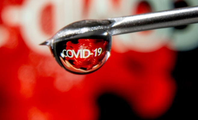 the word covid 19 is reflected in a drop on a syringe needle in this illustration taken november 9 2020 photo reuters