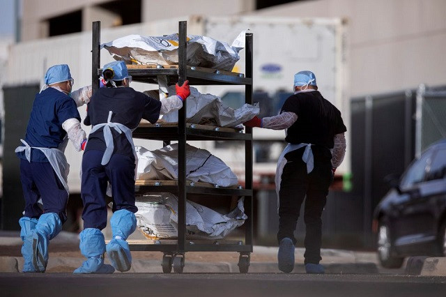 el paso county medical examiner s office staff roll bodies that are in bags labeled covid from refrigerated trailers into the morgue office amid the coronavirus disease covid 19 outbreak in el paso texas us november 23 2020 photo reuters