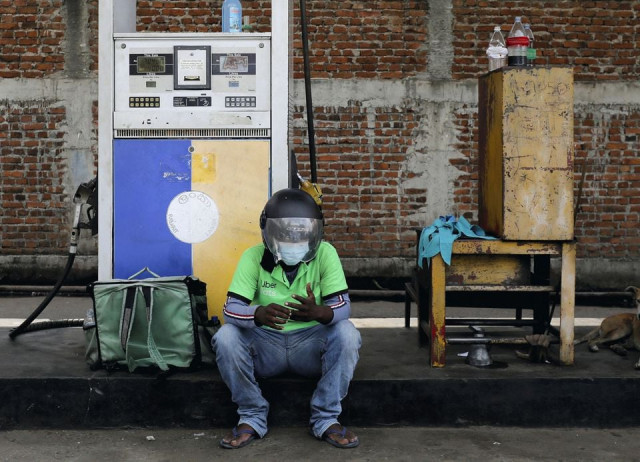 an uber driver waits at a ceylon petroleum corporation fuel station to buy fuel after his bike ran out of petrol on the road in colombo sri lanka march 22 2022 reuters an uber driver waits at a ceylon petroleum corporation fuel station to buy fuel after his bike ran out of petrol on the road in colombo sri lanka march 22 2022 reuters