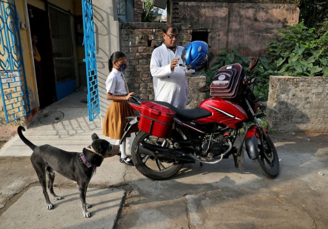 ambika chatterjee 9 a student of fifth grade who according to her father subhasish chatterjee 52 shifted to a low fee charging private school from an elite school waits for her father as he puts on his helmet to drop her to a school in kolkata india april 27 2022 picture taken on april 27 2022 reuters ambika chatterjee 9 a student of fifth grade who according to her father subhasish chatterjee 52 shifted to a low fee charging private school from an elite school waits for her father as he puts on his helmet to drop her to a school in kolkata india april 27 2022 picture taken on april 27 2022 reuters