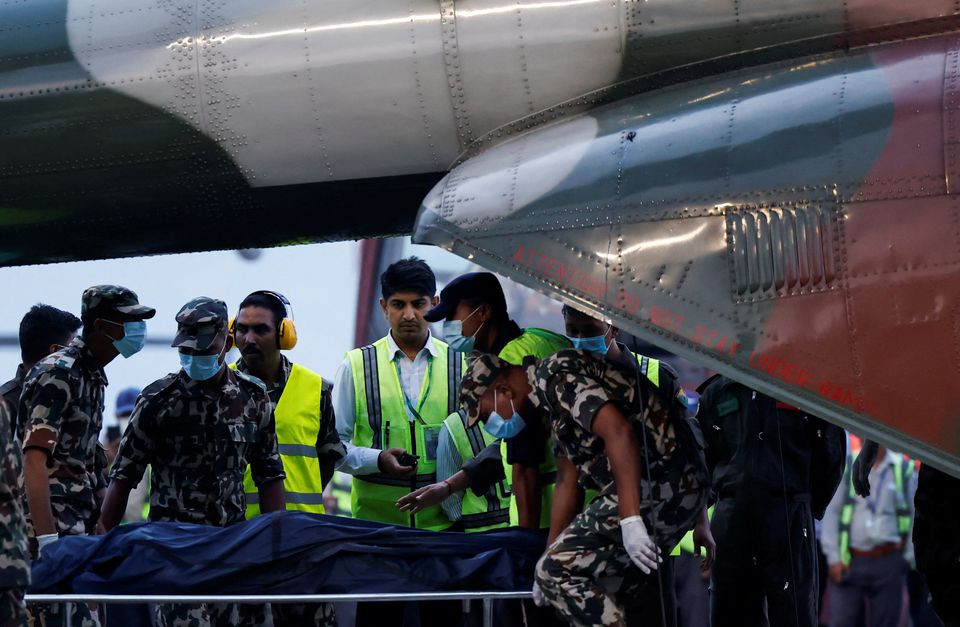 member of nepal army carries the body of a victim of the tara air passenger plane that crashed with 22 people on board while on its way to jomsom from the helicopter at the airport in kathmandu nepal may 30 2022 reuters