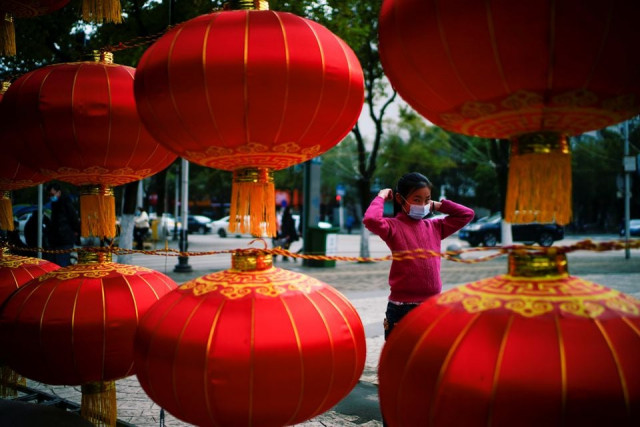 a girl wearing a face mask walks on a street decorated for lunar new year celebrations following an outbreak of the coronavirus disease covid 19 in wuhan hubei province china february 8 2021 photo reuters