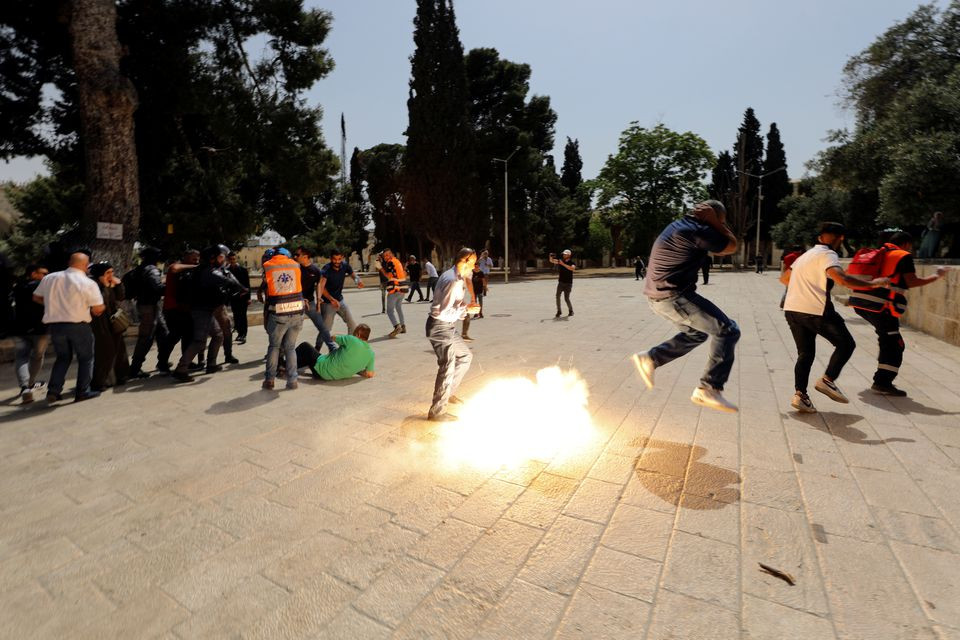 palestinians react as israeli security forces throw stun grenade during clashes at the compound that houses al aqsa mosque known to muslims as noble sanctuary and to jews as temple mount in jerusalem s old city may 21 2021 photo reuters
