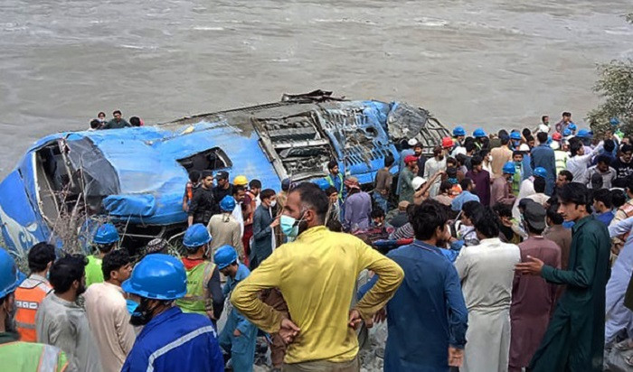 rescue workers and onlookers gather around a wreck after a bus plunged into a ravine following a bomb explosion in kohistan district of khyber pakhtunkhwa province on july 14 2021 afp file