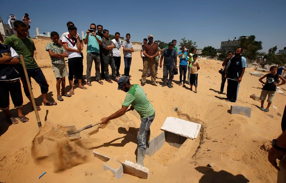 A Palestinian prepares a grave to bury the bodies of the wife of Hamas's military leader, Mohammed Deif, and his infant son Ali, whom medics said were killed in an Israeli air strike, at a cemetery in Beit Lahiya in the northern Gaza Strip August 20, 2014. PHOTO: REUTERS