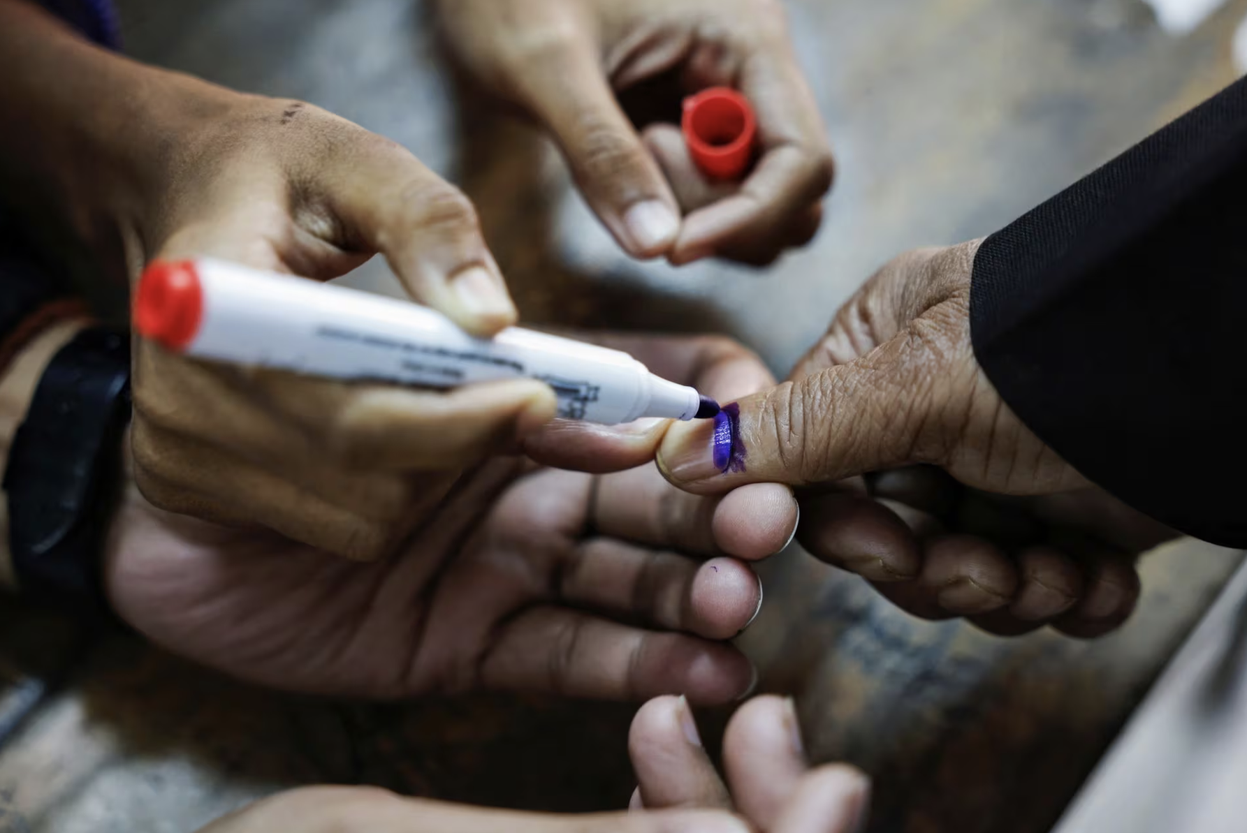 officials mark the thumb of a voter with ink during the casting of vote in the 12th general election in dhaka bangladesh january 7 2024 reuters