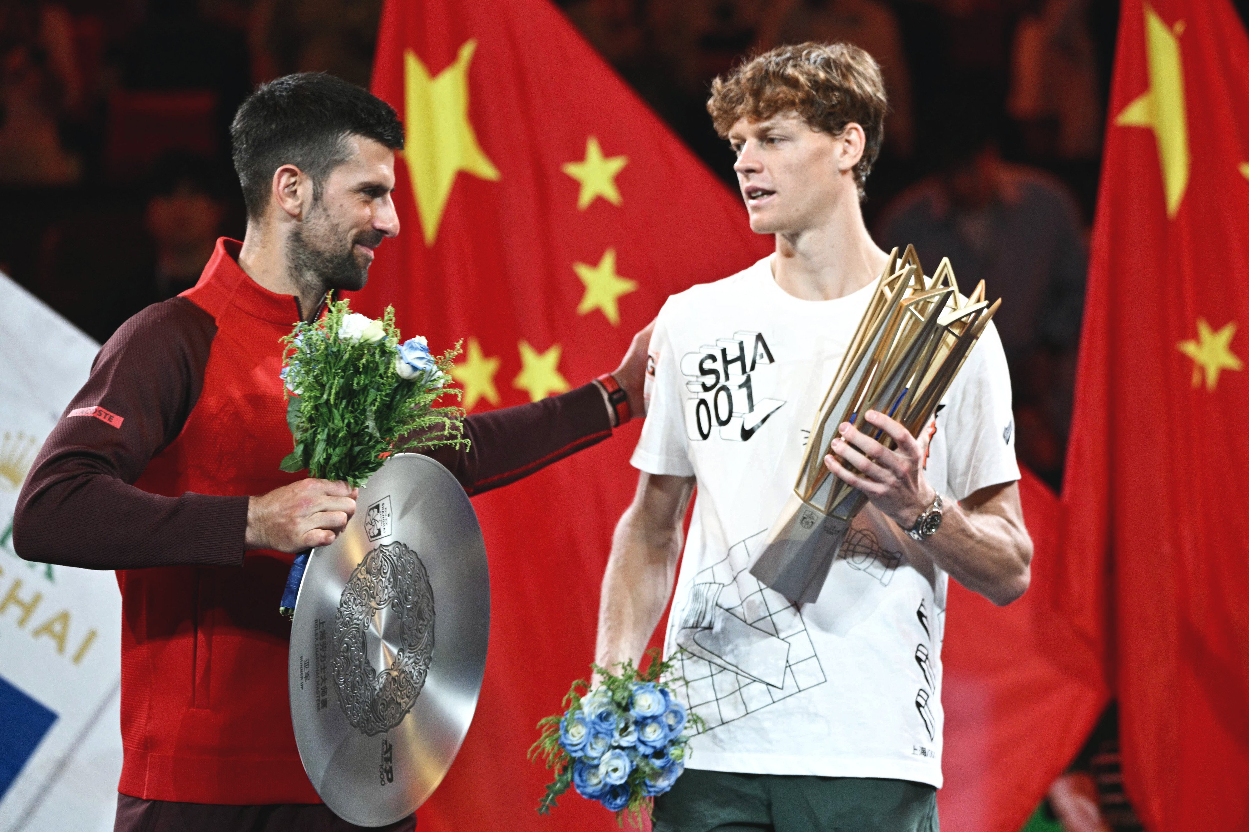 jannik sinner is greeted by novak djokovic after the former won their men s singles final match at the shanghai masters photo afp