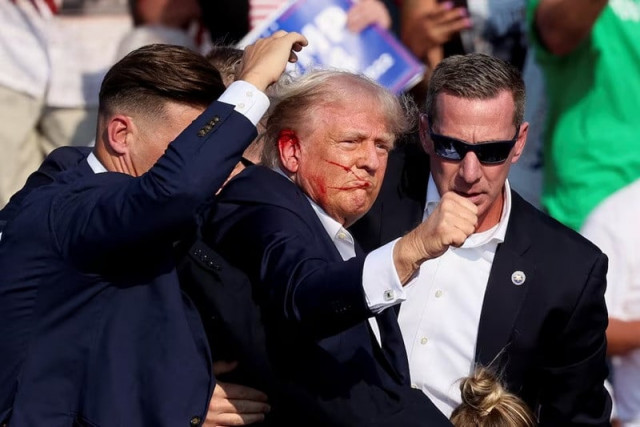 former us president donald trump gestures as he is assisted by the secret service after gunfire rang out during a campaign rally at the butler farm show in butler pennsylvania us july 13 2024 photo reuters former us president donald trump gestures as he is assisted by the secret service after gunfire rang out during a campaign rally at the butler farm show in butler pennsylvania us july 13 2024 photo reuters