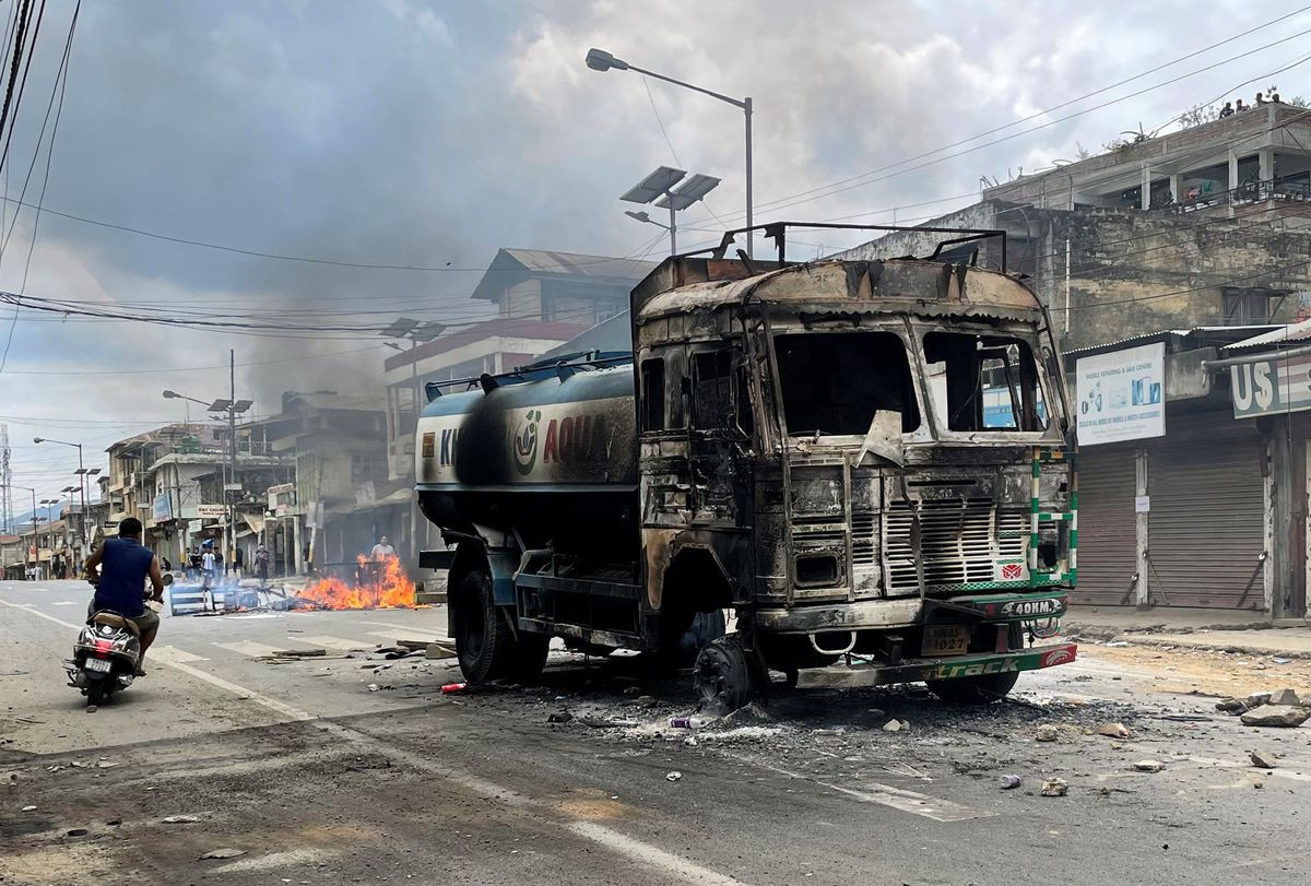 a scooterist rides past a damaged water tanker that was set afire during a protest by tribal groups in churachandpur in the northeastern state of manipur india may 4 2023 photo reuters