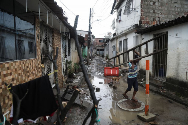 a man carries a ladder amid rubble from houses damaged by heavy rains in the coqueiral neighbourhood in recife brazil may 31 2022 reuters a man carries a ladder amid rubble from houses damaged by heavy rains in the coqueiral neighbourhood in recife brazil may 31 2022 reuters