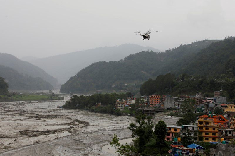 a nepali army helicopter flies above the swollen melamchi river during a rescue mission in sindhupalchok nepal june 16 2021 photo reuters