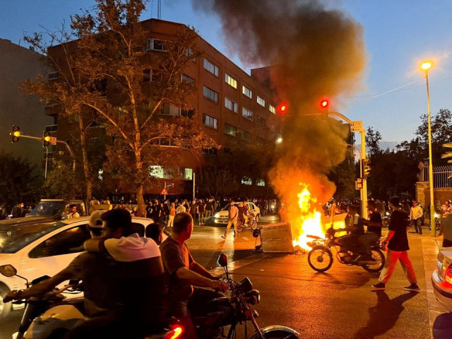 a police motorcycle burns during a protest over the death of mahsa amini a woman who died after being arrested by the islamic republic s morality police in tehran iran september 19 2022 wana west asia news agency via reuters file photo