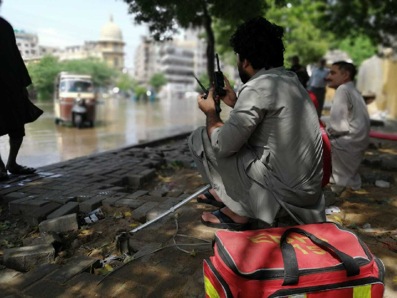 following the thunderstorms edhi workers set up a makeshift office on the footpaths next to the flooded street photo express