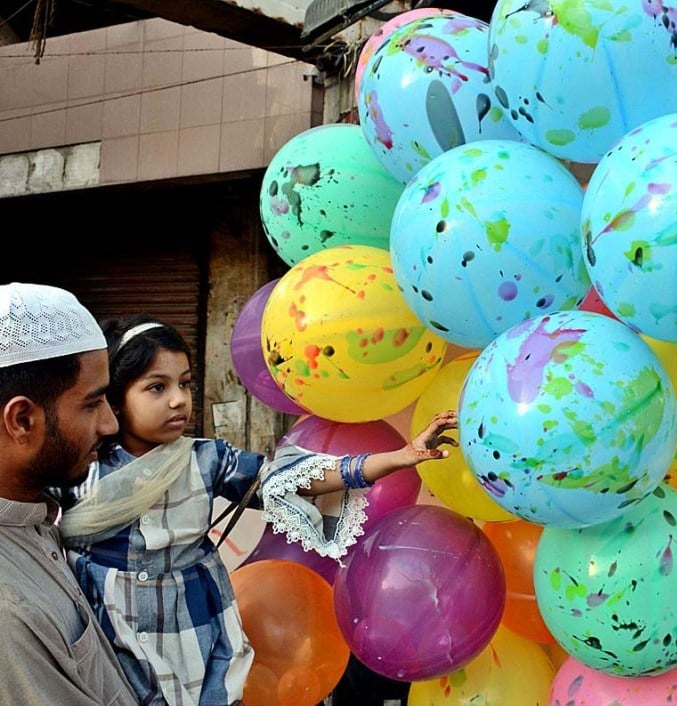 a man buys balloons for children from roadside vendor after offering eidul azha prayer on august 1 2020 photo app