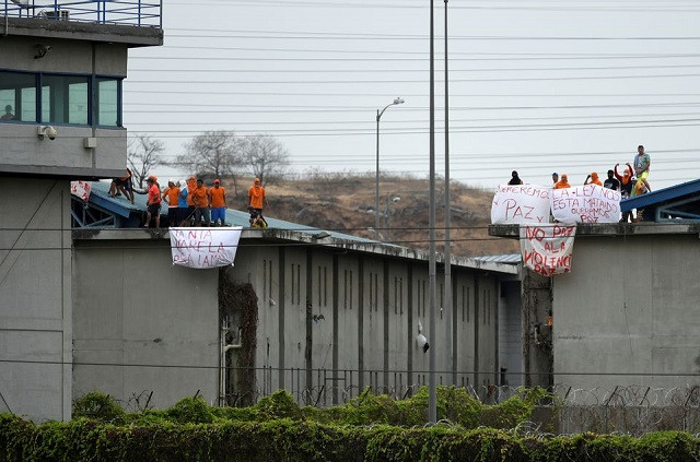 inmates of the regional de guayaquil prison hold banners reading we want peace the law is killing us peace no to violence after unrest was reported since the country s worst ever riots broke out a few days ago at the penitenciaria del litoral in guayaquil ecuador october 2 2021 photo reuters