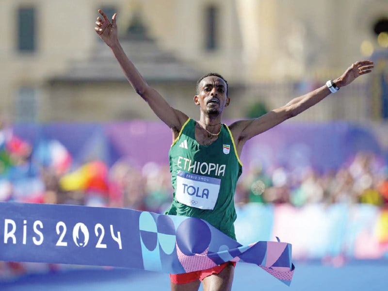 ethiopia s tamirat tola celebrates after winning the men s marathon at the paris olympics photo afp