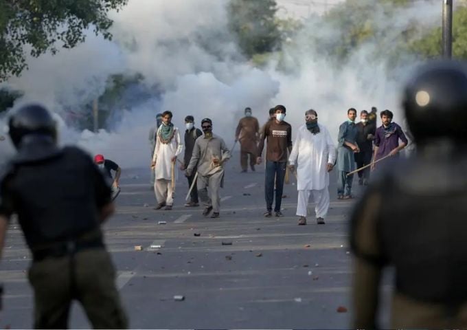 Supporters of Pakistan Tehreek-e-Insaf (PTI) throw stones after police fire tear gas to disperse them in Lahore on May 9, 2023. PHOTO: REUTERS/FILE