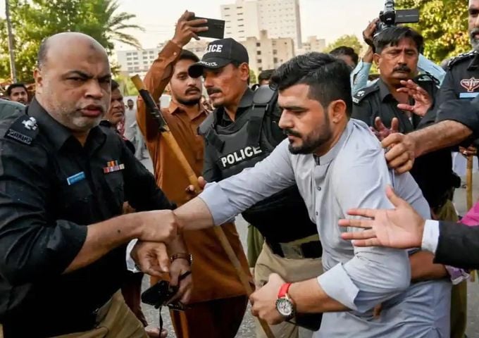 Police personnel detain PTI supporters whilst they protest to demand the release of former prime minister Imran Khan, in Karachi on October 18, 2024. — AFP